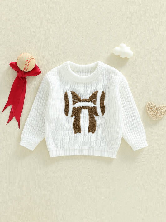 White sweater with brown bear design on a beige background